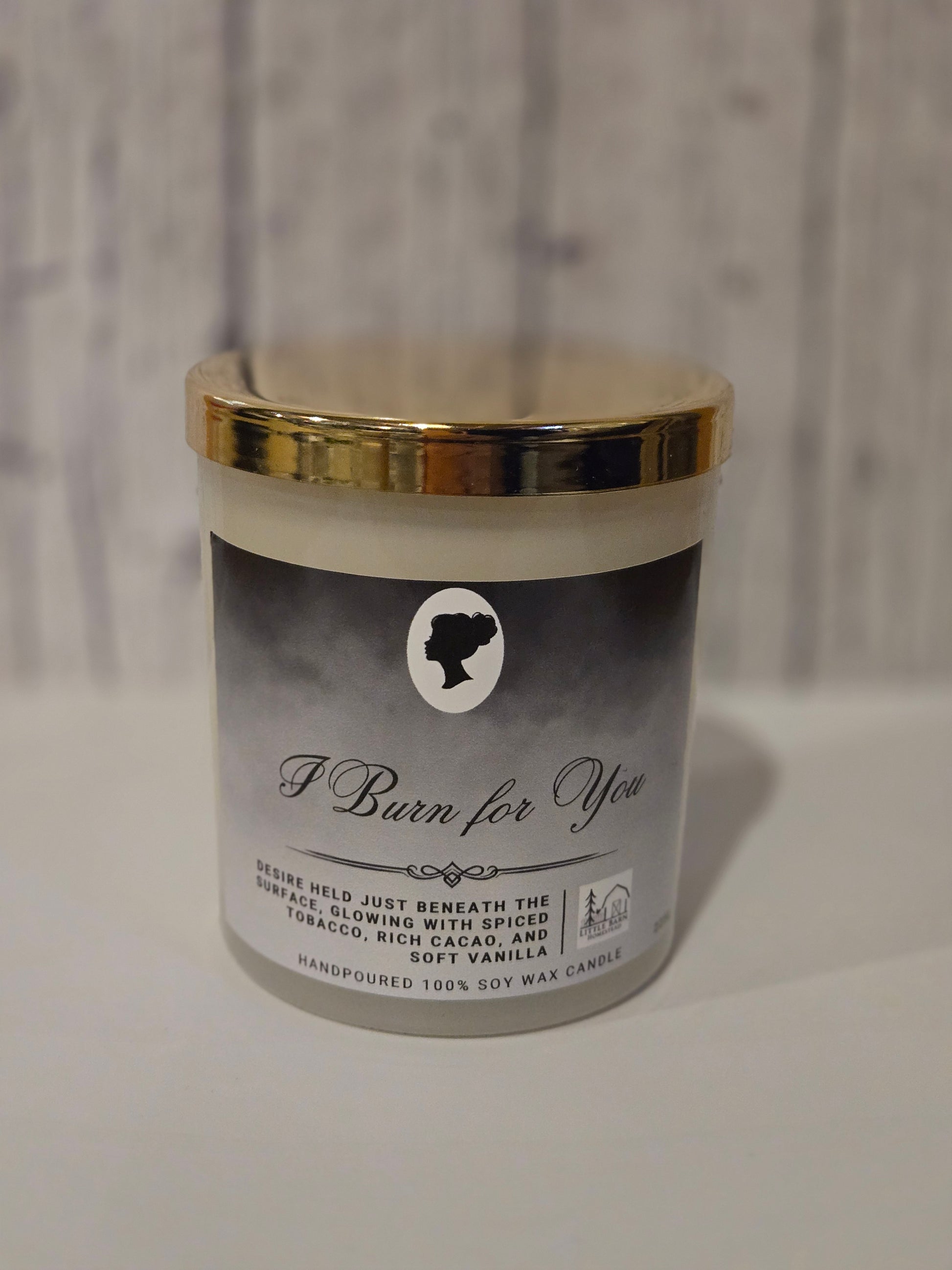 Candle with gold lid and label on a neutral background